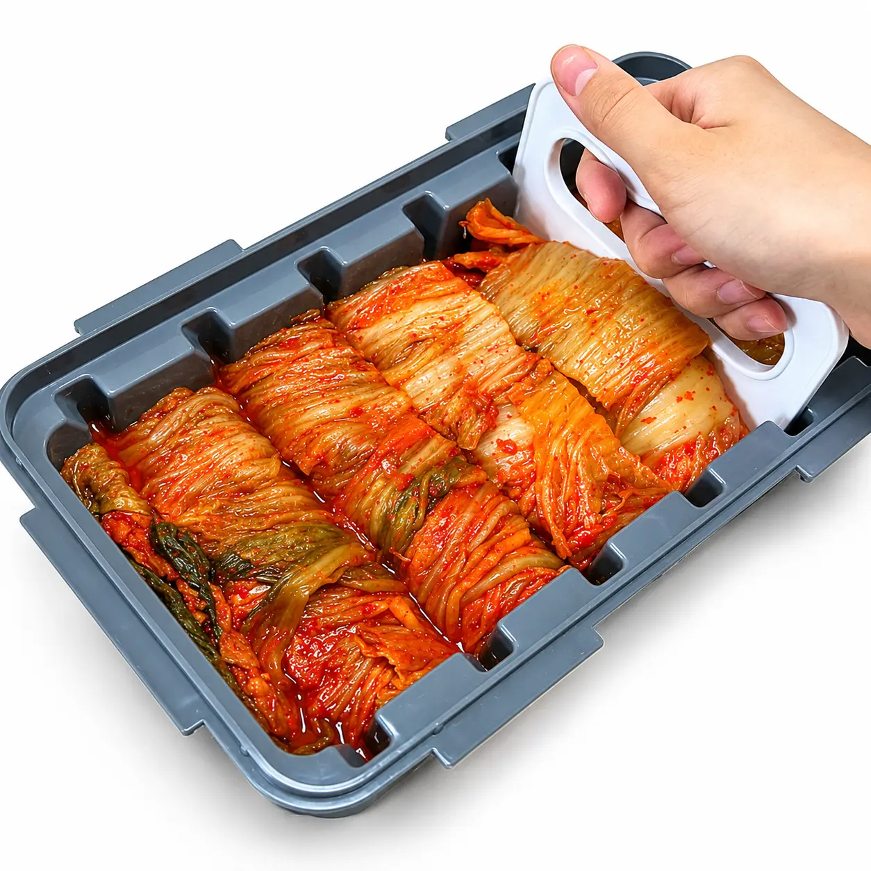 AI-generated illustration of a gray Korean kimchi cutter container filled with napa cabbage kimchi as a hand presses the white cutting tool through the guide slots